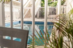 a swimming pool behind a white fence with a table and a plant at Mont Vernon Villas in Cul de Sac