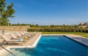 a swimming pool with lounge chairs next to a swimming pool at Villa Tany in Dračan