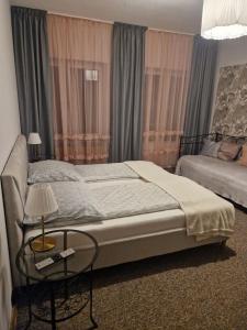 a bedroom with a bed and a table with a lamp at Pensjonat Galicja in Józefów
