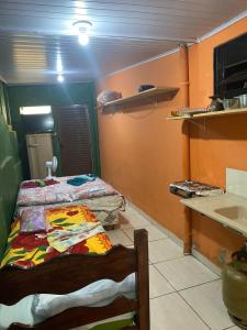 a room with a bed and a kitchen with a counter at Suíte na Serra in São Roque de Minas +2 photos