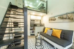 a living room with a couch and a staircase at Quirky Studio in Central Reading in Reading
