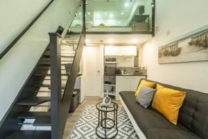a living room with a couch and a staircase at Quirky Studio in Central Reading in Reading +10 photos