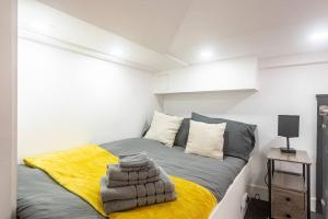 a bedroom with a bed with a yellow blanket at Quirky Studio in Central Reading in Reading
