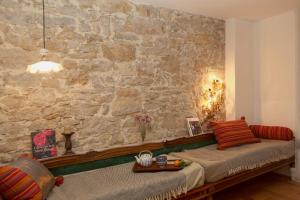 sala de estar con pared de piedra y sofá en Boutique-Hotel Guesthouse Le Locle en Le Locle
