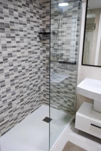 a bathroom with a glass shower and a sink at El Toro Apartments in Altea +29 photos