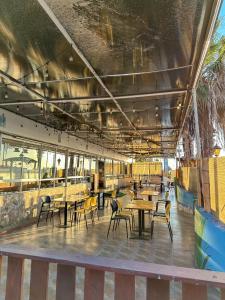 a dining room with tables and chairs and windows at Hotel & Spa Las Taguas in Arica