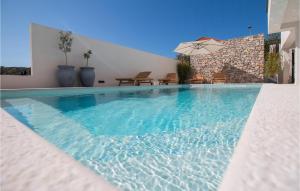 a swimming pool in a house with an umbrella at Beautiful Apartment With Pool in Žman