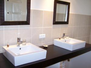 a bathroom with two white sinks and a mirror at Hôtel de Mirmande in Mirmande +62 photos