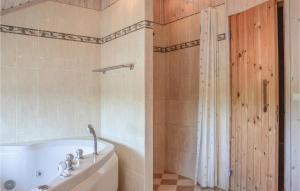 a bathroom with a tub and a sink and a shower at Holiday Home Ørnevej Sjællands Odde Denm in Yderby