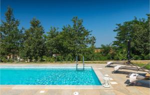 a blue swimming pool with two chairs and trees at Villa Zorica in Stari Pazin +38 photos
