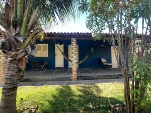 a blue house with a palm tree in front of it at Luar Da Barra in Barra Grande