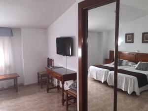 a hotel room with a bed and a mirror at Hotel Martin in Toledo