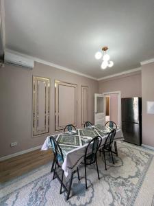 a dining room with a table and chairs and a refrigerator at Жан Айсулу in Türkistan