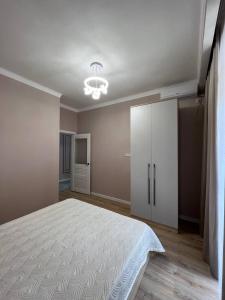 a bedroom with a bed and a white cabinet at Жан Айсулу in Türkistan