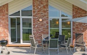 a patio with a table and chairs in front of a building at Cozy Home In Dagebüll With Kitchen in Dagebüll