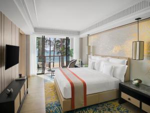a hotel room with a bed and a balcony at InterContinental Phuket Resort by IHG in Kamala Beach
