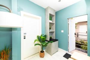 een blauwe gang met een deur en een plant bij Sunny Days Apartments in Miami Beach