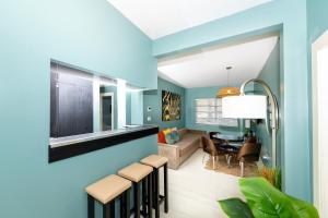 een woonkamer met blauwe muren en een eetkamer bij Sunny Days Apartments in Miami Beach