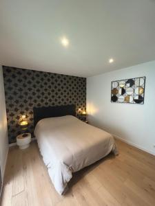 a bedroom with a bed and two lights on the wall at maison rue neuve in Plouay