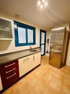 una cocina con fregadero y refrigerador en La Morada de Eva, en Ronda