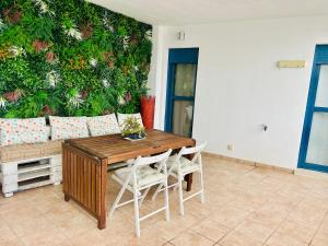 a table and chairs in a room with a wall at La Morada de Eva in Ronda