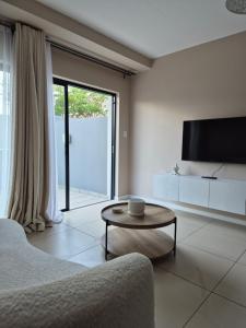 ヨハネスブルグにあるCorporate Luxury - Sandton, Rivoniaのテレビとコーヒーテーブルのあるリビングルーム
