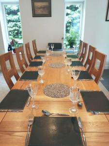 a long wooden table with wine glasses on it at The Highlands - 5 bed 5 bath - Huge Sociable House in Exning