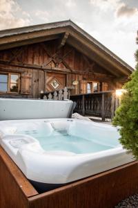 wanna z hydromasażem przed drewnianym domkiem w obiekcie Pineta Natural Chalet w mieście Coredo