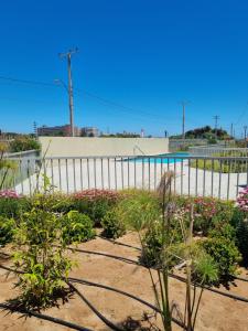 un jardin fleuri devant une clôture dans l'établissement Apartamento a pasos del Mar, à La Serena