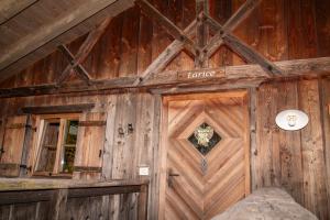 drewniany budynek z drzwiami i oknem w obiekcie Pineta Natural Chalet w mieście Coredo