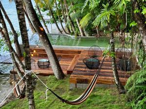 a hammock on a dock in front of the water at Hotel Gringo Perdido in El Remate