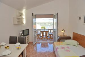 ein Schlafzimmer mit einem Bett und ein Esszimmer mit einem Tisch in der Unterkunft Apartments and Studios Jokić in Tivat
