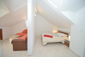 ein kleines Zimmer mit einem Bett und einem Sofa in der Unterkunft Apartments and Studios Jokić in Tivat