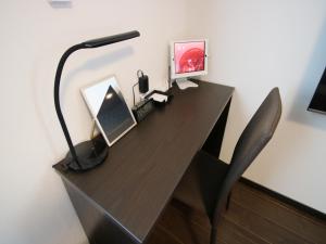 una scrivania nera con lampada e computer; di SA Inn Ina Nice Road - Vacation STAY 90164v a Ina