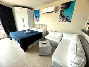 un soggiorno con un letto e un divano di Sophia I - Praia Grande ad Arraial do Cabo