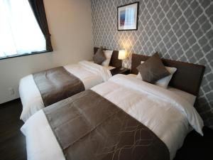 una camera da letto con due letti e una finestra di SA Inn Ina Nice Road - Vacation STAY 90164v a Ina