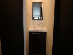 un bagno con lavandino e specchio di SA Inn Ina Nice Road - Vacation STAY 90164v a Ina 1 altra foto