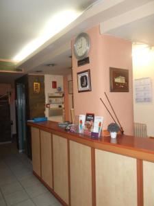 a counter with a clock on a wall at Elite Hotel in Athens