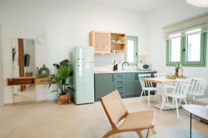 a kitchen with a refrigerator and a table and chairs at Magnolia Villas Potos Thassos in Potos