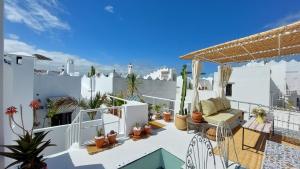 a balcony with a couch and cactus at DAR MOUIMA in Tangier