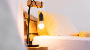 a lamp sitting next to a bed in a room at Apartment Olsa - Cozy Studio in Kandersteg in Kandersteg