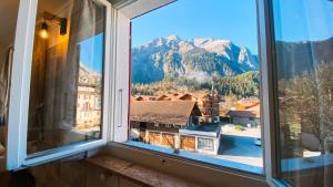 a window with a view of a mountain at Apartment Olsa - Cozy Studio in Kandersteg in Kandersteg