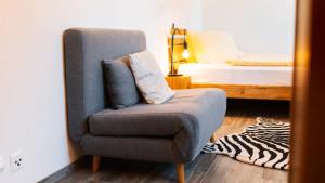 a room with a chair and a bed with a bed sqor at Apartment Olsa - Cozy Studio in Kandersteg in Kandersteg +14 photos