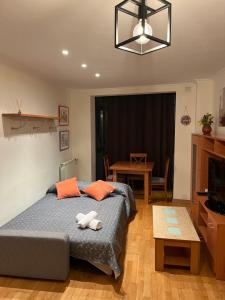 a bedroom with a bed with orange pillows and a table at MAGIC I a 1 minuto de la Catedral y Plaza Mayor in León