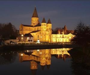 a large castle with its reflection in the water at night at Les Pichies, T3 Django, Digoin in Digoin