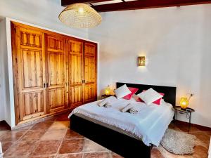 a bedroom with a large bed with wooden cabinets at Finca Reina de la isla in Felanitx +19 photos