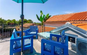 a blue table and chairs on a balcony with an umbrella at 2 Bedroom Cozy Home In Malinska in Malinska +27 photos