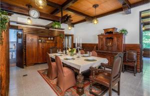 een eetkamer met een tafel, stoelen en een klok bij Nice Home In Cabar With Wifi in Čabar