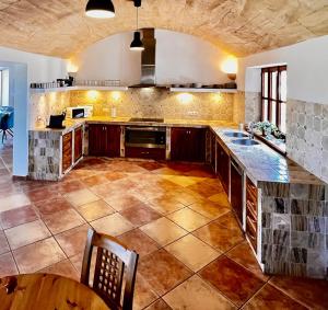 a large kitchen with wooden cabinets and a tile floor at Finca Reina de la isla in Felanitx