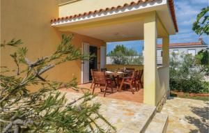 un patio d'une maison avec une table et des chaises dans l'établissement Two-Bedroom Holiday Home In Liznjan, à Ližnjan